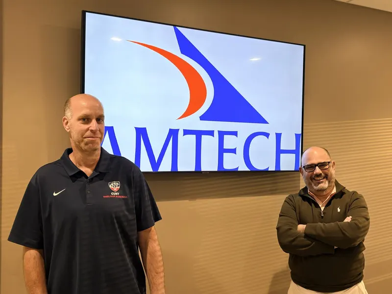 Two people under the Amtech logo at Amtech Software