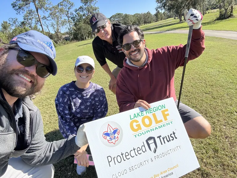 Our foursome with the tournament sign
