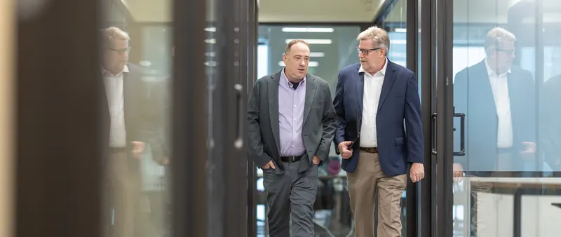 Two of the team walking through the glass door